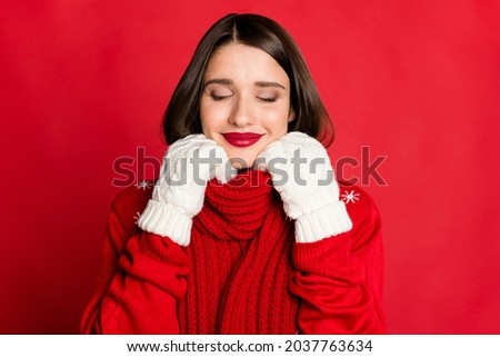 Portrait of attractive dreamy girl wearing cosy clothes newyear eve isolated over bright red color background