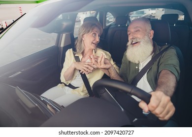 Portrait of attractive elderly retired cheerful couple riding car having fun telling funny stories spending holiday day rest