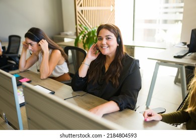 Retrato de una atractiva trabajadora que se siente feliz en el centro de llamadas y trabaja en el servicio de atención al cliente 