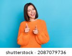 Portrait of attractive flirty funny cheerful girl winking pointing forefingers at you isolated over vibrant blue color background