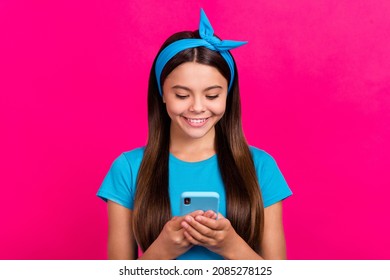 Portrait Of Attractive Focused Cheerful Long-haired Girl Using Device App Isolated Over Shine Pink Magenta Color Background