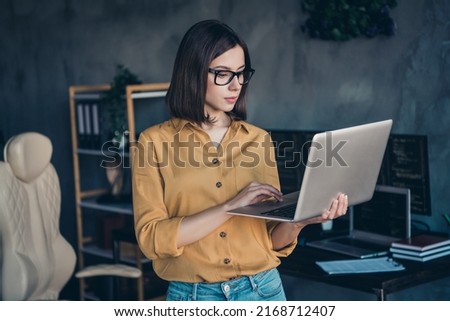 Portrait of attractive focused skilled girl expert typing email editing project task at workplace workstation indoors