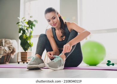 Portrait of attractive focused sportive girl doing physical activity preparing yoga class at light home indoors - Powered by Shutterstock