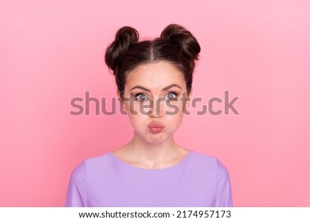 Portrait of attractive funny girl blowing cheeks fooling tease isolated over pink pastel color background