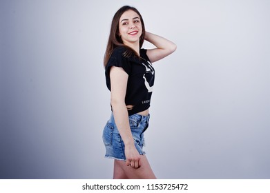 Portrait Of An Attractive Girl In Black T-shirt Saying Lol And Denim Shorts Posing In The Studio.