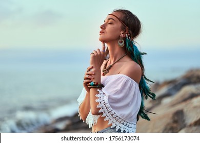 Portrait Of Attractive Hippie Woman Wearing Blue Feathers In Long Hair, Jewelry And White Blouse With Closed Eyes. Indie Boho Chic Style