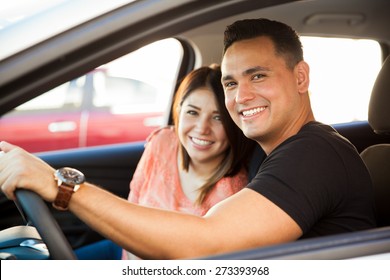 Portrait Of An Attractive Hispanic Couple Driving A Car And About To Go On A Trip