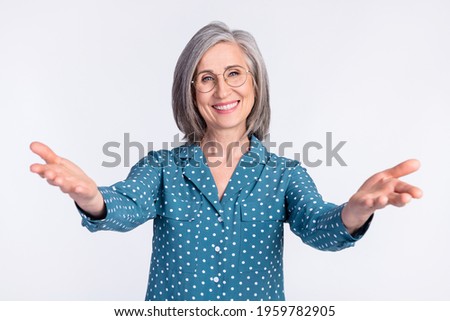 Portrait of attractive kind cheerful middle-aged lady hugging meeting you isolated over gray light pastel color background