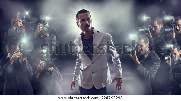 Portrait of attractive male vip celebrity\
posing in front of photographers\
paparazzi