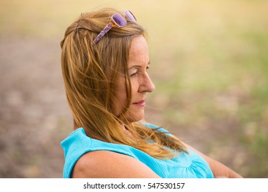 Portrait Attractive Mature Woman, Sad, Thoughtful, Depressed, Sitting Lonely Outdoor, Blurred Background, Copy Space.