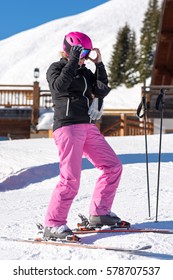 Portrait Of An Attractive Middle Aged Woman Getting Dressed For Skiing In Front Of A Skiing Hut