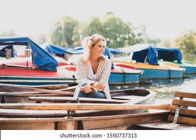 Portrait of an attractive middle-aged woman in front of boats at a lake