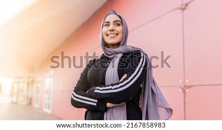 portrait of attractive muslim sporty woman with hijab outdoors