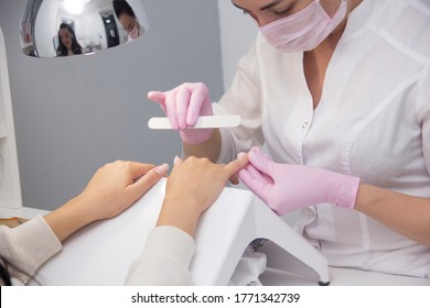 Portrait Of An Attractive Nail Salon Worker Giving A Manicure To One Of Her Regular Customers