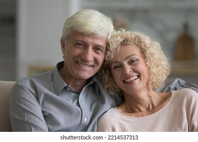 Portrait Of Attractive Optimistic Older Spouses, Close Up Shot. Happy Marriage, Harmonic Relationships, Homeowners Loving Couple With Wide Toothy Smile Staring At Camera Posing At Modern Home. Love