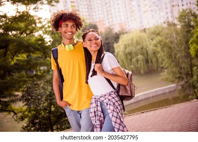 Portrait of attractive positive cheerful couple best friends spending weekend free time strolling at green forest outdoors