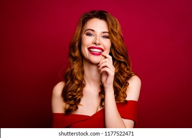 Portrait Of Attractive, Pretty, Dreamy, Charming, Success Curly Ginger Woman Look At Camera Isolated On Deep Red Background Holds A Finger Near The Lips And Smile