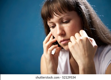 Portrait Attractive Sad  Woman With Cellular Telephone On The Blue Background