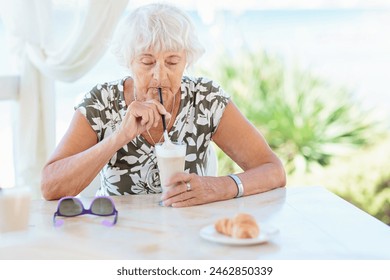 Portrait of attractive senior woman sitting in a summer outdoor cafe and drinking coffee - Powered by Shutterstock