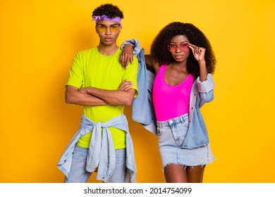 Portrait Of Attractive Serious Cool Funky Couple Posing Wearing Denim Clothes Touching Specs Isolated Over Bright Yellow Color Background