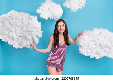Portrait of attractive slim cheerful wavy-haired girl touching soft clouds flying isolated over bright blue color background - Shutterstock ID 2205769255
