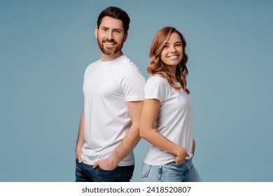 Portrait of attractive smiling couple posing isolated on blue background. Happy bearded man and beautiful woman wearing stylish white t shirt looking at camera in studio - Powered by Shutterstock