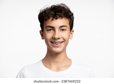 Portrait of attractive smiling teenage boy with braces looking at camera, isolated on white background. Dental concept, treatment, health care - Powered by Shutterstock