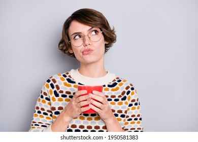 Portrait of attractive suspicious girl drinking cacao overthinking copy space isolated over grey pastel color background - Shutterstock ID 1950581383