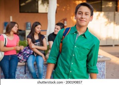 Portrait of an attractive teenage boy and his friends hanging out at school