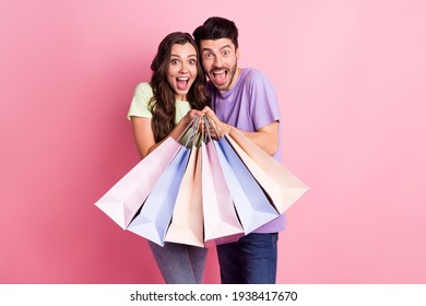 Portrait of attractive trendy amazed cheerful couple carrying new things hugging black friday isolated on pink pastel color background - Powered by Shutterstock