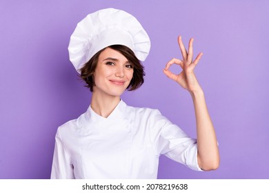 Portrait of attractive trendy cheerful chef showing ok-sign perfect delicious taste isolated over bright violet purple color background