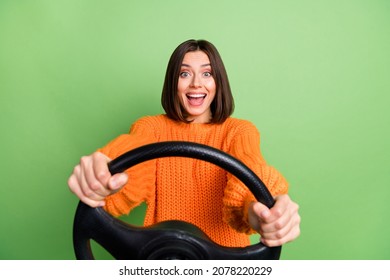 Portrait of attractive trendy cheerful funny girl holding steering wheel driving good mood isolated over bright green color background