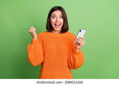 Portrait d'une fille séduisante et joyeuse utilisant un appareil dont les commentaires de réjouissances suivent isolés sur fond vert clair : photo de stock