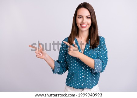 Portrait of attractive trendy cheerful girl demonstrating copy empty space ad offer isolated over grey pastel color background
