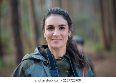 Portrait of attractive woman in forest. Female model with dark hair and ponytail looking at camera. Portrait, beauty concept - Powered by Shutterstock