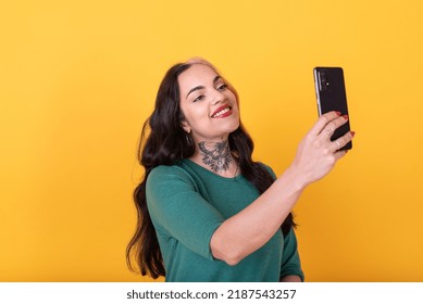 Portrait Of An Attractive Woman Making A Selfie Over Yellow Background. Studio Shot. Studio Shot.