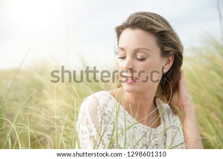 Portrait of attractive woman sitting in wildgrass