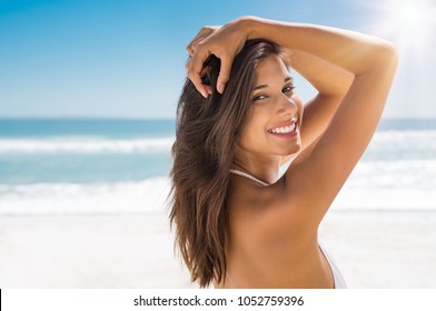 Portrait of attractive woman standing at beach and looking at camera. Happy smiling girl relaxing at seaside during summer vacation. Closeup of beautiful young latin woman with copy space. - Powered by Shutterstock