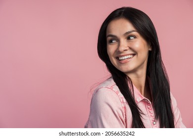 Portrait Of Attractive Woman Standing And Looking Away Over Her Shoulder With Toothy Smile Isolated On Pink Background. Confident Woman Concept 