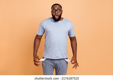 Portrait Of Attractive Worried Nervous Guy Showing Empty Pockets Oops Isolated Over Beige Pastel Color Background