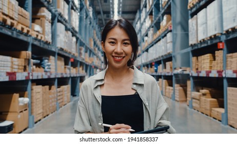 Portrait Of Attractive Young Asia Businesswoman Manager Smiling Charmingly Looking At Camera Hold Digital Tablet Stand In Retail Shopping Center. Distribution, Logistics, Packages Ready For Shipment.