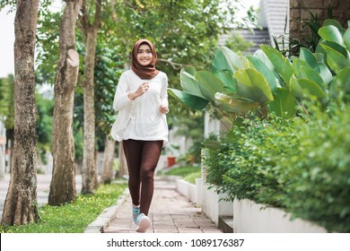 Portrait Of Attractive Young Asian Muslim Woman Running And Exercising Outdoor