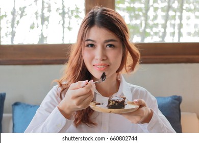 Portrait Of Attractive Young Asian Woman Eating Brownie Chocolate Cake In Coffee Cafe.