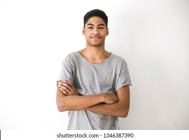 Portrait of an attractive young black man. Handsome afro american boy, teenager. Smiling guy with his hands on his chest on a white background. 