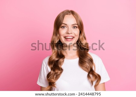 Portrait of attractive young brown wavy hair model adorable girl in white stylish t shirt toothy smiling isolated on pink color background