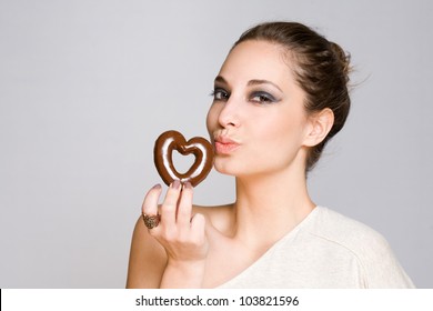 Portrait of an attractive young brunette with shiny chocolate heart.