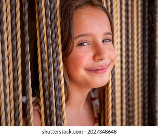 A Portrait Of An Attractive Young Caucasian Woman With Long Blond Hair In Suspenders Peeking Through The Curtains Of Her Front Door