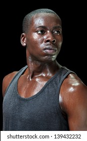 Portrait Of Attractive Young Fit Black Male Athlete Sweating Profusely With Intense Expression Of Determination On Black Background