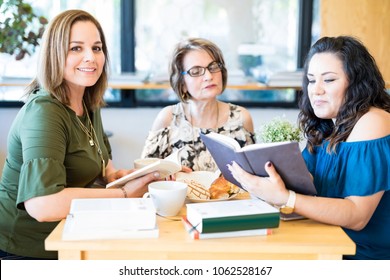 Portrait Of Attractive Young Hispanic Woman With Friends Reading Book At A Book Club