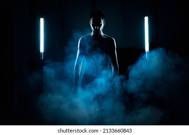 Portrait Of Attractive Young Male Model In Cinematic Backlight On Black Background Without Shirt. Science Fiction.